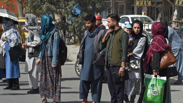 Warga Afghanistan berdiri di pinggir jalan saat menunggu taksi di Kabul pada 15 Agustus 2021. Foto: WAKIL KOHSAR / AFP)