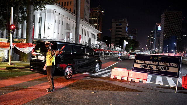 Petugas kepolisian berjaga di pos pemeriksaan ganjil genap selama perpanjangan PPKM level 4 di Jalan MH Thamrin, Jakarta, Minggu (15/8/2021). Foto: Hafidz Mubarak A/ANTARA FOTO