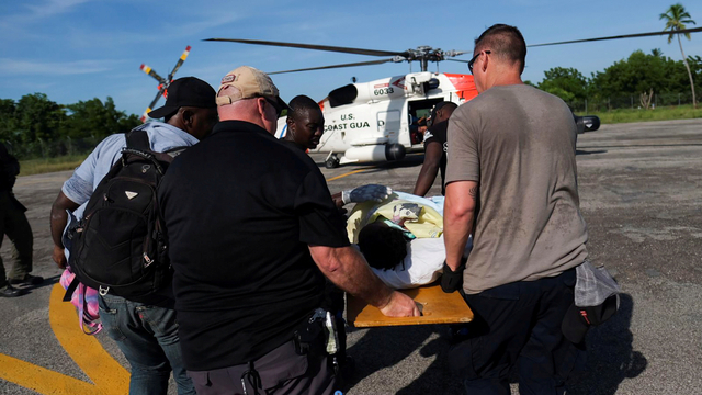 Anggota Penjaga Pantai AS membawa korban gempa ke helikopter untuk evakuasi, di Les Cayes, Haiti, Senin (16/8). Foto: Ricardo Arduengo/REUTERS