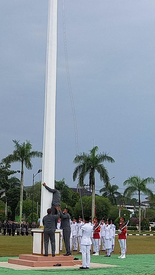 Sejumlah pelatih saat berusaha memperbaiki pengait bendera yang putus.