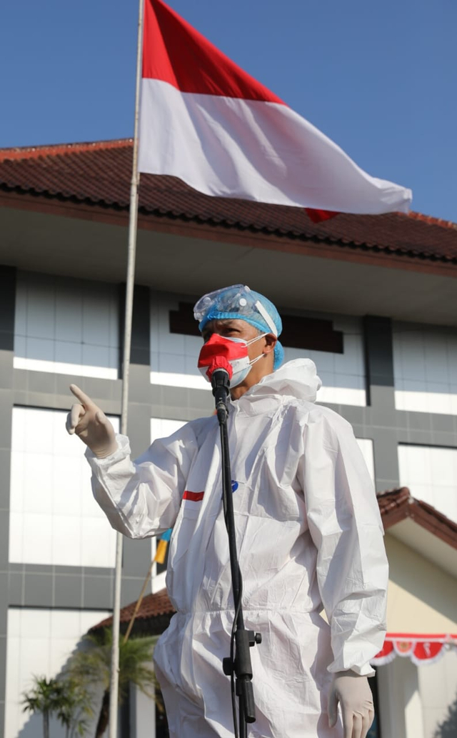 Gubernur Jateng Ganjar Pranowo mengenakan baju hazmat lengkap saat pimpin upacara HUT ke-76 RI. Foto: Pemprov Jateng