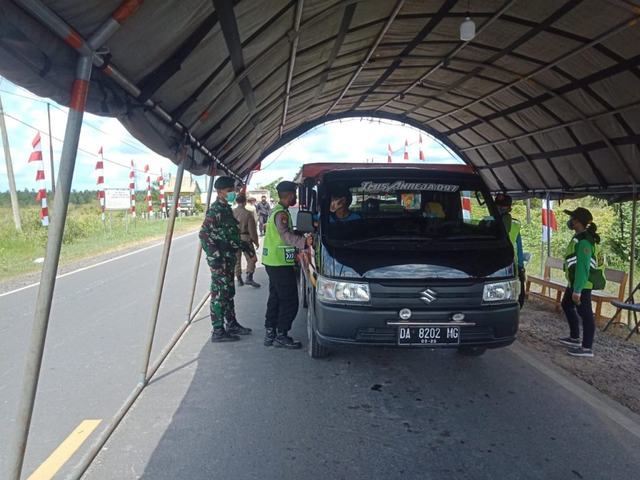 Petugas Satgas COVID-19 saat melakukan pemeriksaan terhadap para pelaku perjalanan darat di pintu masuk Kota Palangka Raya.