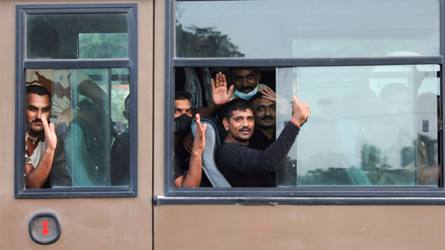Warga India yang dievakuasi dari Kabul melambai dari dalam bus Polisi Perbatasan Indo-Tibet (ITBP) saat meninggalkan Stasiun Angkatan Udara Hindon di Ghaziabad, India, Selasa (17/8).
 Foto: Anushree Fadnavis/REUTERS