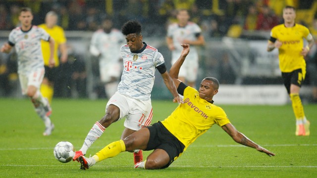 Pemain Borussia Dortmund Manuel Akanji berebut bola dengan pemain Bayern Muenchen Kingsley Coman di Signal Iduna Park, Dortmund, Jerman, Selasa (17/8). Foto: Leon Kuegeler/REUTERS