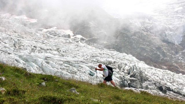 Seorang pendaki berjalan melewati gletser Bionnassay, gletser terkecil dari kompleks Mont Blanc di Prancis, yang menyusut di bawah pengaruh pemanasan global. Foto: REUTERS/Yann Tessier