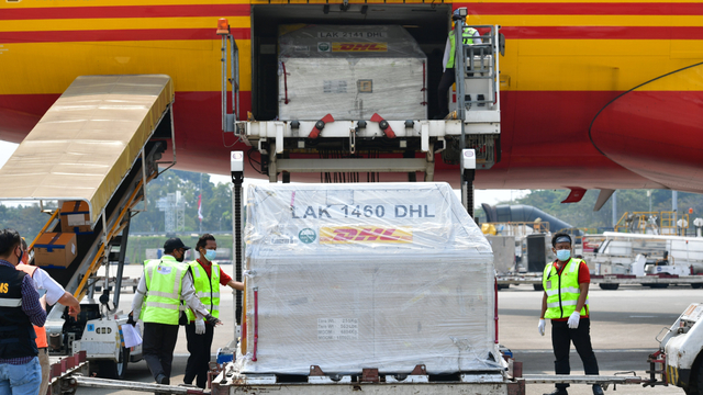 Petugas cargo membawa envirotainer berisi vaksin COVID-19 Pfizer setibanya di Terminal Cargo Bandara Internasional Soekarno Hatta, Tangerang, Banten, Kamis (19/8/2021). Foto: Kominfo