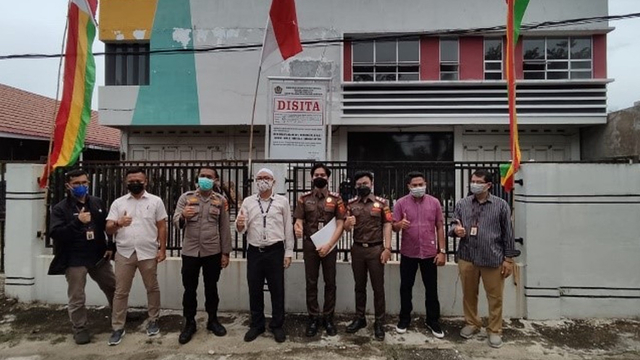 TIM Kanwil Ditjen Pajak Riau berfoto di depan aset yang disita dari wajib pajak. 