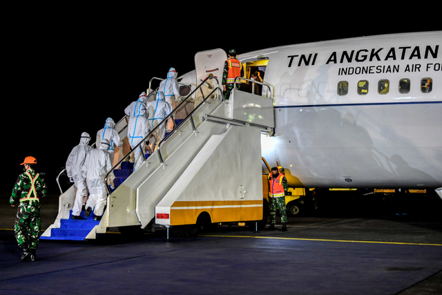 Petugas kesehatan berjalan menuju pesawat untuk memeriksa kondisi WNI yang dievakuasi dari Afghanistan saat tiba di Bandara Halim Perdanakusuma, Sabtu (21/8/2021) dini hari. Foto: Galih Pradipta/Antara Foto