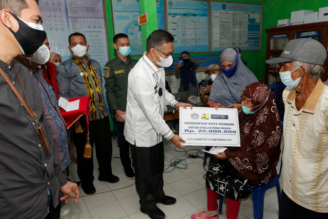 Wali Kota Kendari, Sulkarnain Kadir, saat menyerahkan bantuan secara simbolis kepada warga penerima bantuan. Foto: Andi May/kendarinesia.