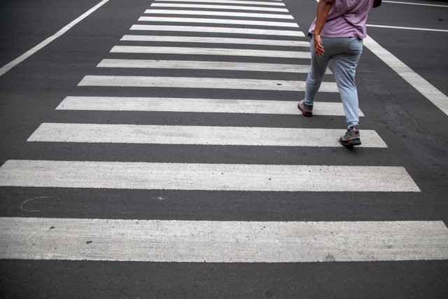 Pejalan kaki menyeberang jalan melalui zebra cross. Foto: Shutter Stock