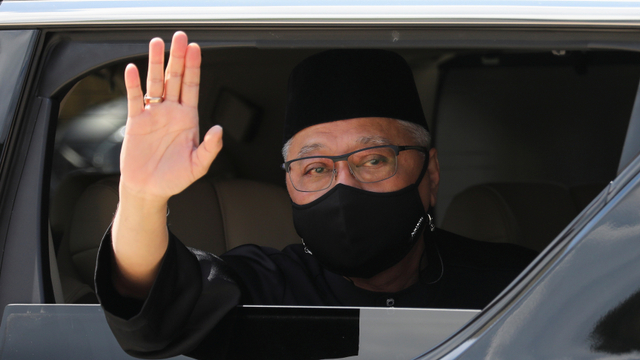 Perdana Menteri baru Malaysia Ismail Sabri Yaakob melambai dari mobil, saat ia pergi setelah upacara peresmian, di Kuala Lumpur. Foto: REUTERS/Lim Huey Teng