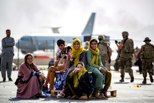 Anak-anak pengungsi menunggu penerbangan berikutnya setelah diturunkan di Bandara Internasional Hamid Karzai, di Kabul, Afghanistan, Kamis (19/8/2021). Foto: Mark Andries/AS Korps Marinir/ Reuters