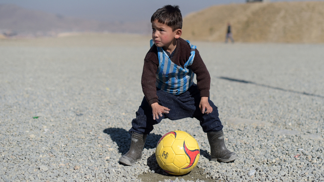 Anak laki-laki Afghanistan Murtaza Ahmadi, seorang penggemar muda Lionel Messi, bermain sepak bola di Kabul pada 1 Februari 2016. Foto: AFP / Shah Marai