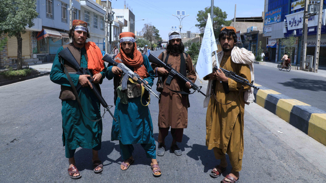 Pejuang Taliban berjaga di sepanjang jalan di Herat, Afghanistan, pada 19 Agustus 2021. Foto: AREF KARIMI / AFP