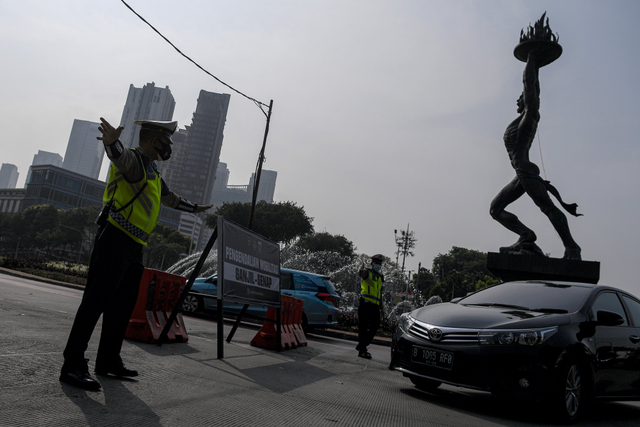 Polisi mengatur lalu lintas kendaraan di pos penerapan ganjil genap di kawasan Bundaran Senayan, Jakarta, Selasa (24/8/2021). Foto: Sigid Kurniawan/Antara Foto