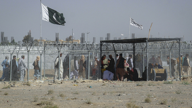 Warga negara Afghanistan dan Pakistan berjalan melintasi perbatasan di titik penyeberangan perbatasan Pakistan-Afghanistan di Chaman, Selasa (24/8). Foto: AFP