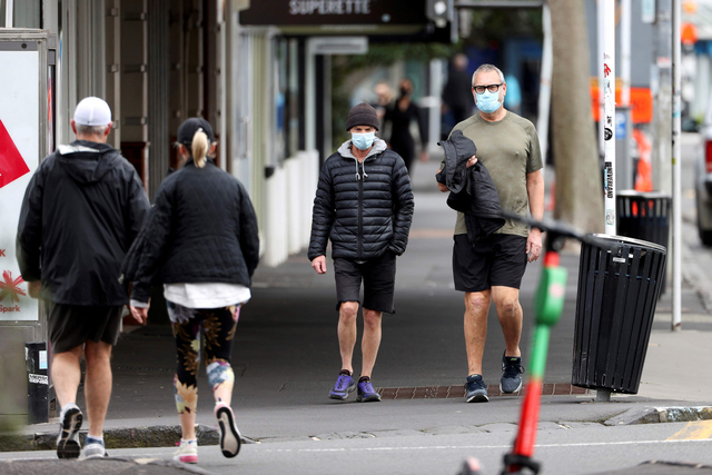 Warga memakai masker saat berolahraga di tengah pemberlakuan lockdown di Auckland, Selandia Baru, Kamis (26/8/2021). Foto: Fiona Goodall/Reuters