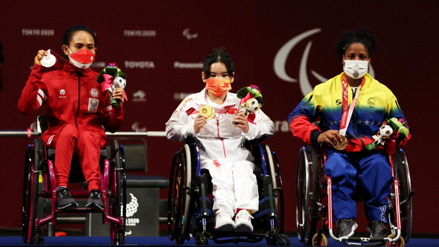 Atlet powerlifting Indonesia Ni Nengah Widiasih (kiri) menunjukkan medali perak yang diraihnya di Paralimpiade Tokyo 2020 di Tokyo International Forum, Jepang, Kamis (26/8/2021). Foto: Molly Darlington/REUTERS
