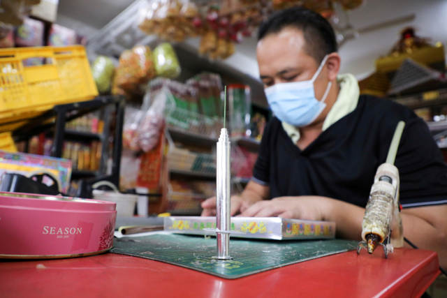 Pekerja menyelesaikan pembuatan vaksin kertas buatan tangan di Johor Bahru, Malaysia. Foto: Lim Huey Teng/REUTERS