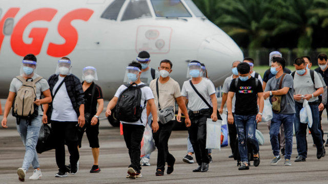Puluhan Tenaga Kerja Asing (TKA) asal China meninggalkan pesawat seusai mendarat di Bandar Udara Cut Nyak Dhien Kabupaten Nagan Raya, Aceh, Jumat (11/9/2020). Foto: SYIFA YULINNAS/ANTARA FOTO