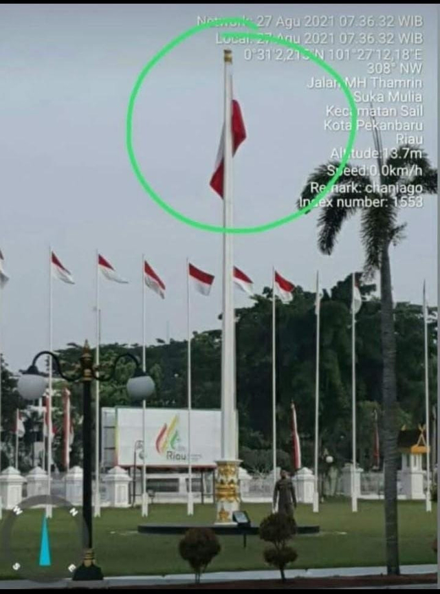 SEORANG anggota Polisi Pamong Praja menjauh dari tiang bendera yang terpasang bendera merah putih terbalik, Jumat pagi (27/8/2021), di Kompleks Gubernuran Riau. 