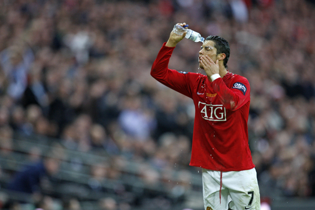 Pemain Manchester United Cristiano Ronaldo menyiramkan air ke wajahnya saat Final Piala Carling 2009. Foto: ADRIAN DENNIS / AFP