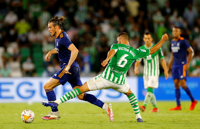 Pemain Real Madrid Gareth Bale berebut bola dengang pemain Real Betis Victor Ruiz di Estadio Benito Villamarin, Seville, Spanyol. Foto: Marcelo Del Pozo/Reuters