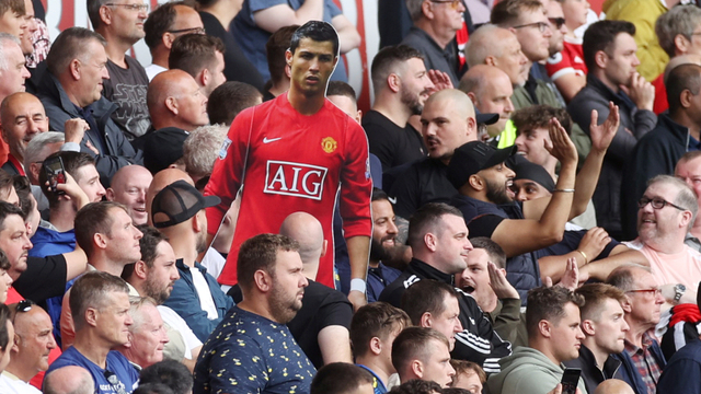 Penggemar Manchester United memegang potongan gambar Cristiano Ronaldo di Stadion Molineux, Wolverhampton, Inggris, Minggu (29/8). Foto: Action Images via Reuters