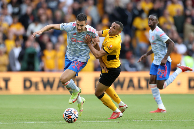 Pemain Manchester United Diogo Dalot berebut bola dengan pemain Wolverhampton Wanderers pada pertandingan liga Inggris di Stadion Molineux, Wolverhampton, Inggris. Foto: Carl Recine/REUTERS