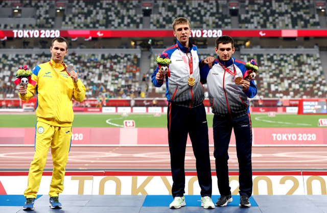 (kiri-kanan) peraih perak Ihor Tsvietov dari Tim Ukraina, peraih medali emas Dmitrii Safronov dari Rusia dan peraih medali perunggu Artem Kalashian dari cabang olahraga lari 100 m. Foto: Tasos Katopodis/Getty Images