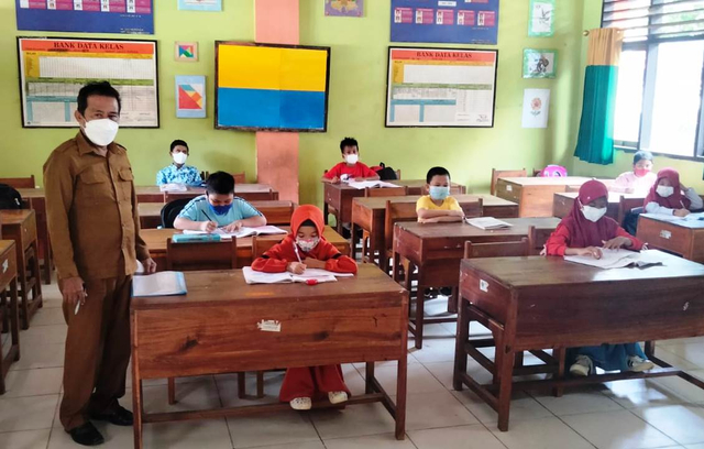 Kepala SDN 25 Kendari, Rustam, pada pembelajaran tatap muka hari pertama di sekolah, siswa duduk berjarak, kapasitas hanya 50 persen. Foto: Andi May/kendarinesia.