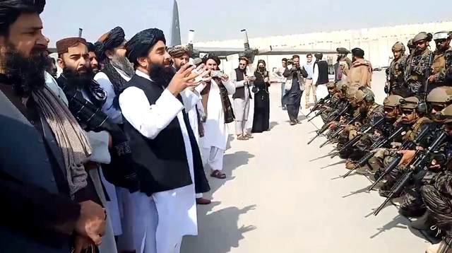 Juru bicara Taliban Zabihullah Mujahid berbicara kepada unit militer Badri 313 di bandara Kabul, Afghanistan, Selasa (31/8). Foto: Taliban/Handout via REUTERS