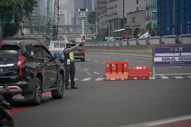 Polisi mengarahkan mobil ber-plat akhir angka genap pada titik ganjil-genap M.H Thamrin di Bundaran Patung Kuda dekat Monas, Rabu (1/9/2021). Foto: Jamal Ramadhan/kumparan