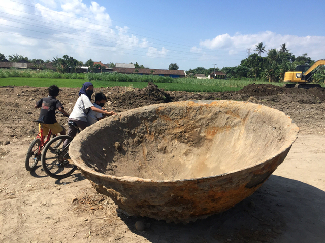 Anak-anak melihat wajan berukuran raksasa peninggalan Belanda ditemukan di Pedukuhan Kretek, Bantul, Daerah Istimewa Yogyakarta (DIY). Foto: Arfiansyah Panji Purnandaru/kumparan