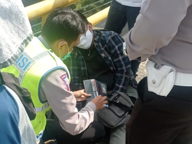 Polisi memeriksa dompet MN yang sebelumnya berupaya bunuh diri, meloncat dari Jembatan Soekarno Hatta (Suhat) yang ketinggiannya 12 meter dari permukaan air sungai. dok