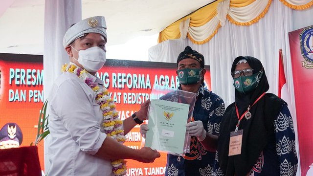 Wakil Menteri Agraria Tata Ruang dan Badan Pertanahan Nasional (ATR/BPN), Surya Tjandra, menyerahkan sertifikat redistribusi tanah dan pelepasan kawasan hutan lindung di Desa Lancang Kuning, Kabupaten Bintan. Foto: Istimewa.