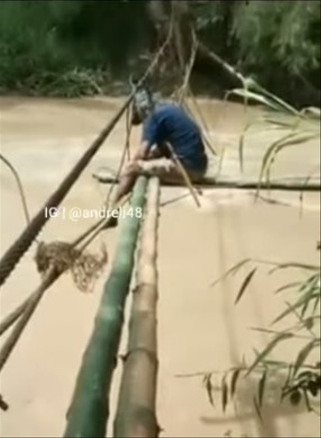 Viral momen miris seorang ayah di Dusun Tirowali, Desa Malela, Kabupaten Luwu, Sulawesi Selatan, memperbaiki sendiri jembatan rusak agar anaknya bisa lewat untuk beli beras. (Foto: Instagram/@andreli48)