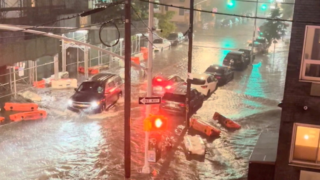 Sebuah kendaraan bergerak di sepanjang jalan yang tergenang banjir di Williamsburg, New York City, New York, Amerika Serikat.  Foto: JAYMEE SIRE/via REUTERS