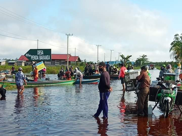 Sejumlah perahu masyarakat setempat saat menanti kendaraan roda dua untuk diangkut melewati banjir.