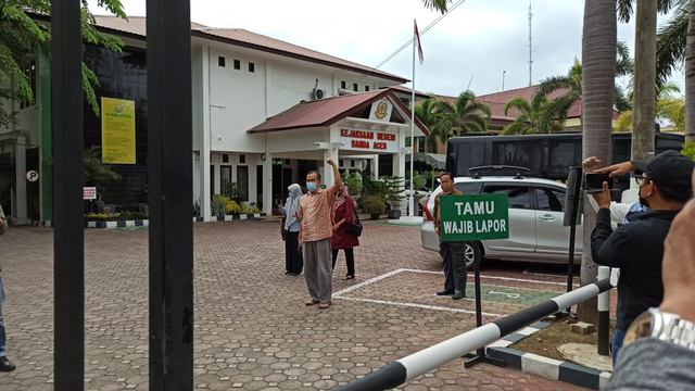 Dosen USK Dr Saiful Mahdi (batik) saat tiba di Kejaksaan Negeri Banda Aceh yang diantar istri beserta teman sejawatnya untuk menjalani eksekusi putusan dalam perkara UU ITE, Kamis (2/9). Foto: Husaini/acehkini