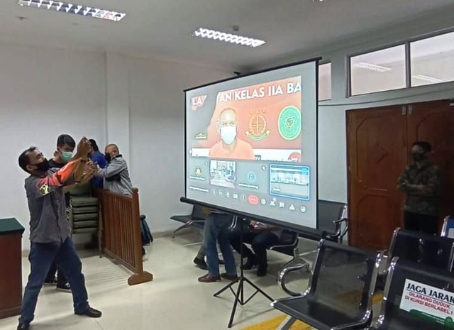 Seorang wartawan mengabadikan jalannya persidangan kasus penadahan besi scrab curian yang berlangsung virtual di PN Batam.