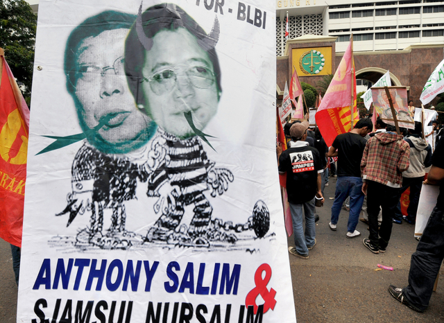 Pengunjuk rasa Indonesia menampilkan spanduk yang menunjukkan Sjamsul Nursalim (kiri) dan Anthony Salim (kanan) pada 22 Juli 2008. Foto: Adek Berry/AFP