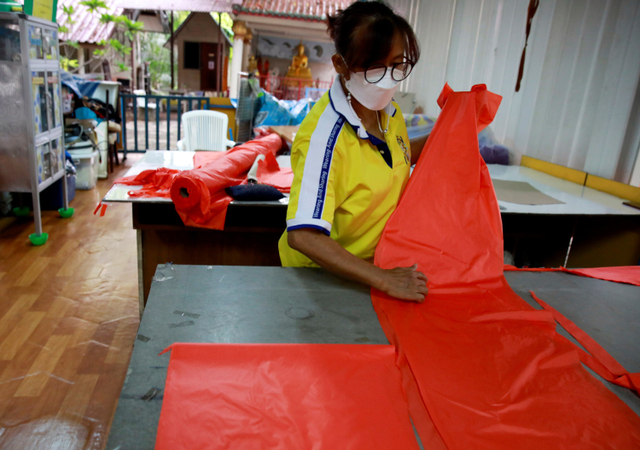 Pekerja menyelesaikan pembuatan alat pelindung diri (APD) yang terbuat dari bahan baku daur ulang sampah botol plastik di Bangkok, Thailand.  Foto: Soe Zeya Tun/REUTERS