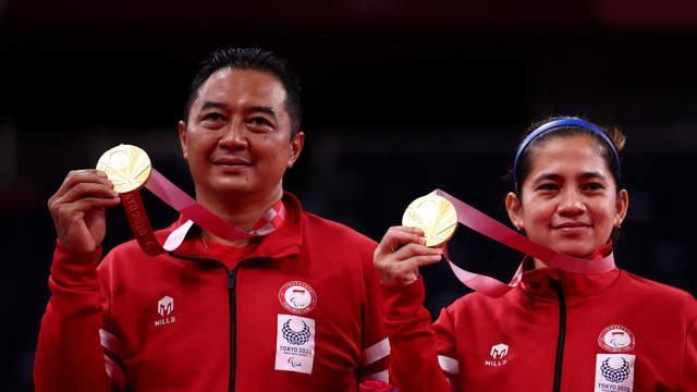 Ganda campuran Indonesia Hary Susanto dan Leani Ratri Oktila merayakan medali emas usai menang di partai final Paralimpiade Tokyo 2020 di Stadion Nasional Yoyogi, Tokyo, Jepang. Foto: Athit Perawongmetha/REUTERS