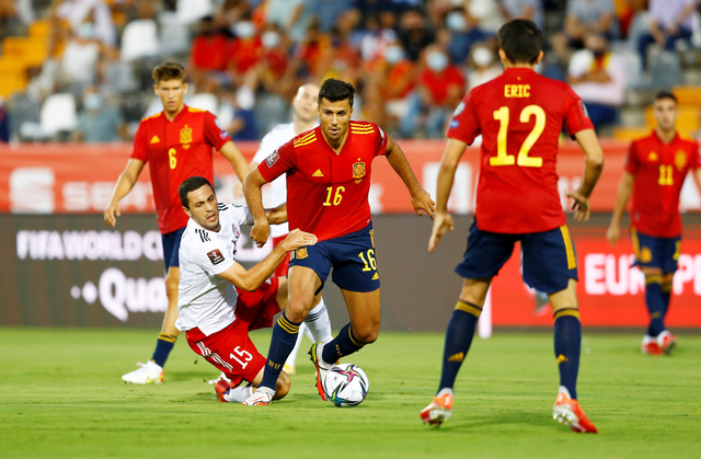 Pemain Spanyol Rodri duel dengan pemain Georgia Giorgi Aburjania saat kualifikasi Piala Dunia antara Spanyol vs Georgia di Estadio Nuevo Vivero, Badajoz. Foto: Marcelo Del Pozo/Reuters