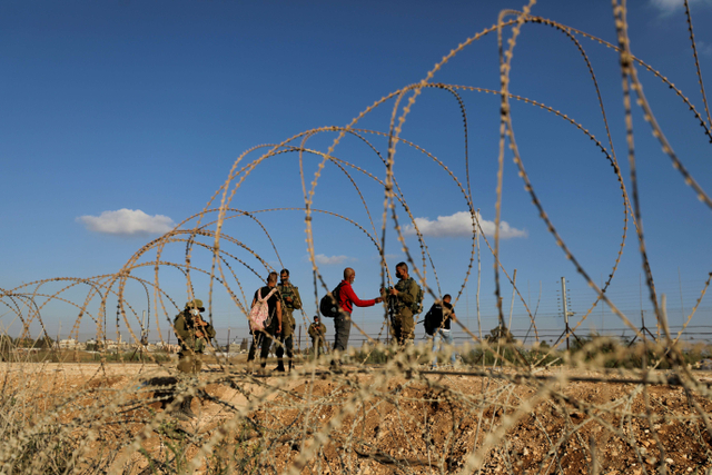 Tentara Israel memeriksa dokumen warga Palestina saat mereka menyeberang kembali ke Tepi Barat dari Israel melalui desa Muqeibila, Senin (6/9). Foto: Ammar Awad/Reuters