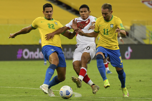 Pemain Peru Edison Flores (tengah) berebut bola dengan pemain Brasil Lucas Verissimo (kiri) dan Ribeiro pada laga kualifikasi Amerika Selatan untuk Piala Dunia FIFA Qatar 2022. Foto: Nelson Almeida / AFP
