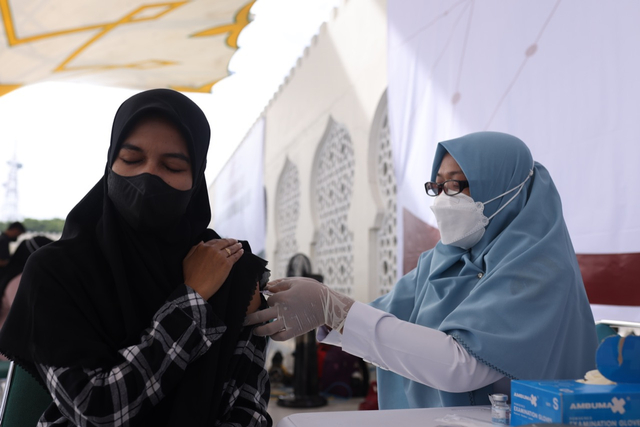 Warga menerima suntikan vaksin COVID-19 di halaman Masjid Raya Baiturrahman, Aceh, Selasa (7/9). Foto: Abdul Hadi/acehkini