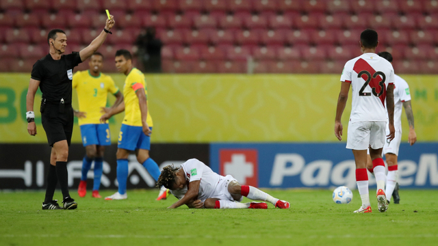 Wasit memberikan kartu kuning kepada pemain Brasil Gabriel usai melanggar pemain Peru dalam laga Kualifikasi  Piala Dunia. Foto: REUTERS/Ricardo Moraes