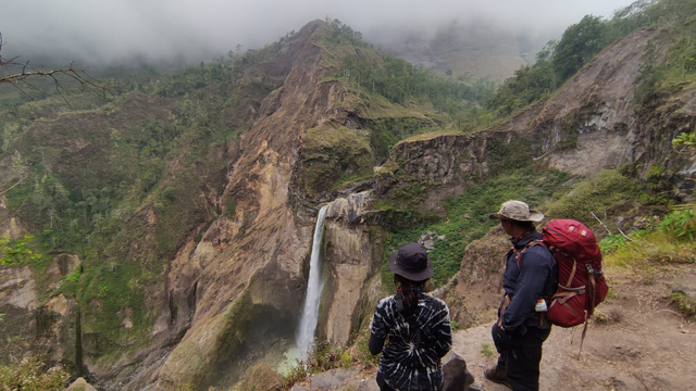 Dua orang pendaki sendang melihat kecantikan Air Terjun Panimbungan yang berada di jalur pendakian Torean. Foto: Harley Sastha